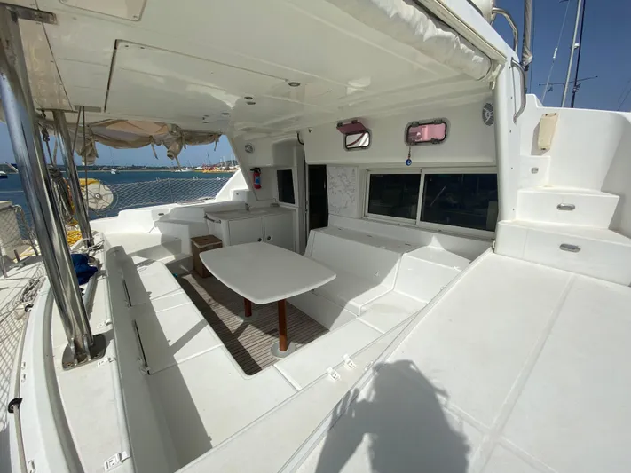  Yacht Photos Pics 2009 Lagoon 440 catamaran interior with white seating and table, docked by the sea.
