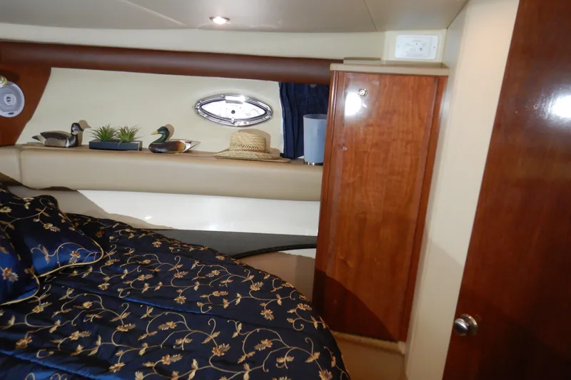 Odyssey Yacht Photos Pics Luxurious interior of 2008 Meridian 411 Sedan with elegant bedding and wooden cabinetry.