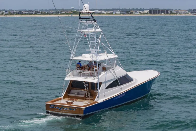 Safari Yacht Photos Pics 2022 Viking 72 Convertible yacht cruising on open water near coastline.