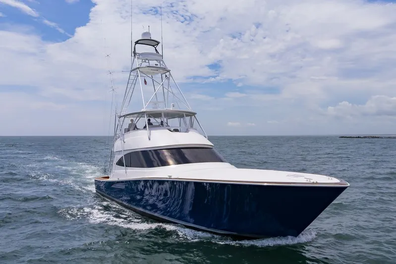 Safari Yacht Photos Pics 2022 Viking 72 Convertible yacht cruising on open sea under a partly cloudy sky.