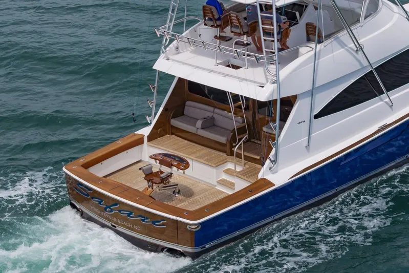Safari Yacht Photos Pics 2022 Viking 72 Convertible yacht cruising on ocean waters, featuring a spacious deck.
