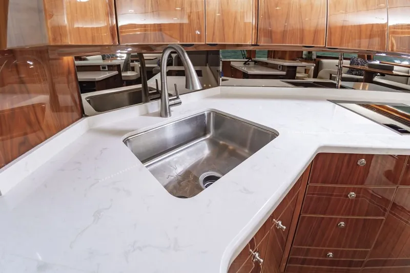 Safari Yacht Photos Pics Luxurious kitchen interior of 2022 Viking 72 Convertible yacht with sleek countertops and modern sink.