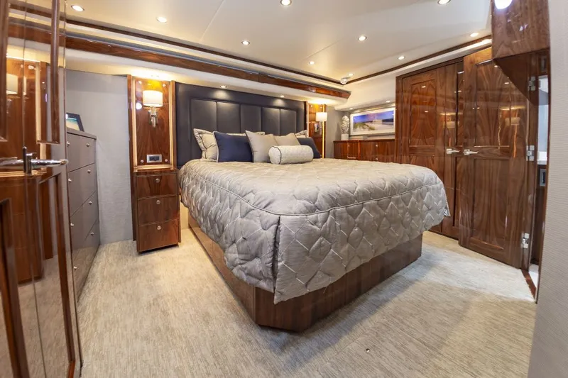 Safari Yacht Photos Pics Luxurious bedroom interior of 2022 Viking 72 Convertible yacht with elegant wood finishes.
