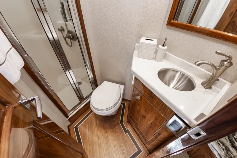 Safari Yacht Photos Pics Luxurious bathroom in 2022 Viking 72 Convertible yacht with shower, toilet, and sink.