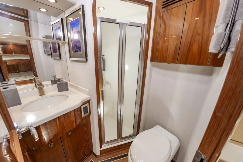 Safari Yacht Photos Pics Luxurious bathroom in 2022 Viking 72 Convertible yacht with modern fixtures and wood accents.
