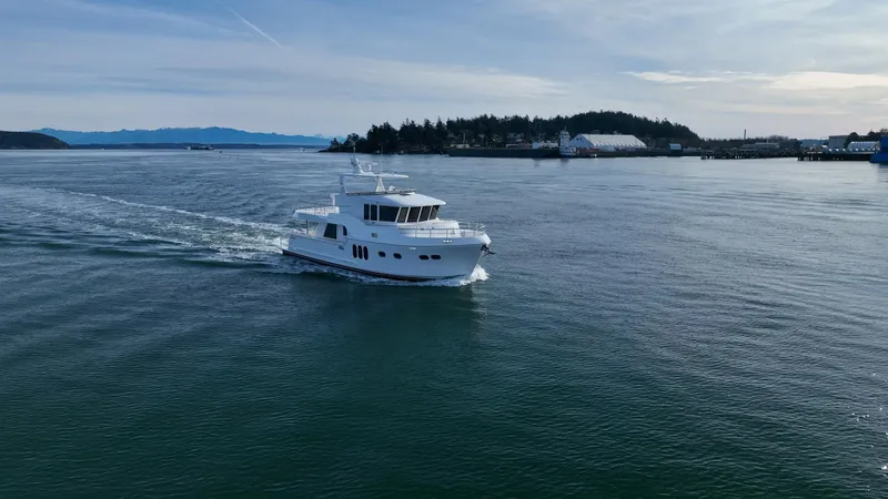 Oasis Yacht Photos Pics 2024 Northwest 55 yacht cruising on calm waters near a scenic coastline.