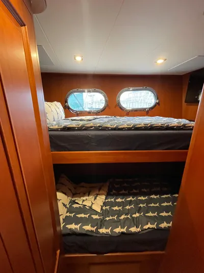 Oasis Yacht Photos Pics Bunk beds in 2024 Northwest 55 yacht cabin with porthole windows and shark-themed bedding.