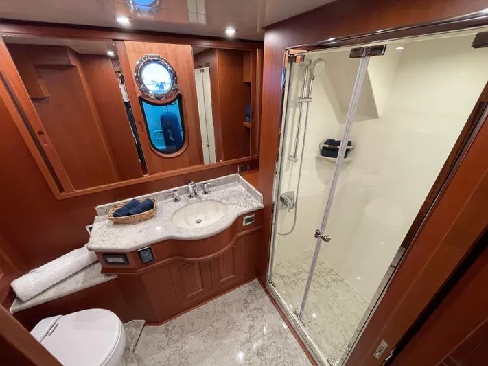 Oasis Yacht Photos Pics Luxurious bathroom in 2024 Northwest 55 yacht with marble countertop and glass shower.
