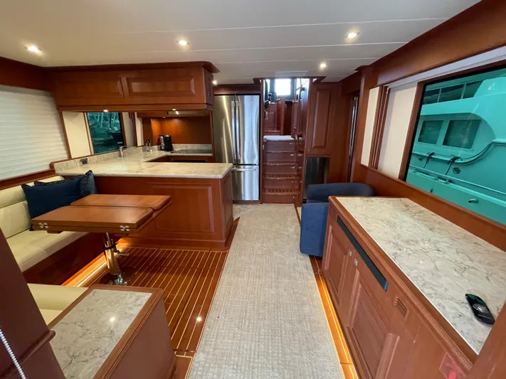 Oasis Yacht Photos Pics Luxurious interior of 2024 Northwest 55 yacht with modern kitchen and dining area.