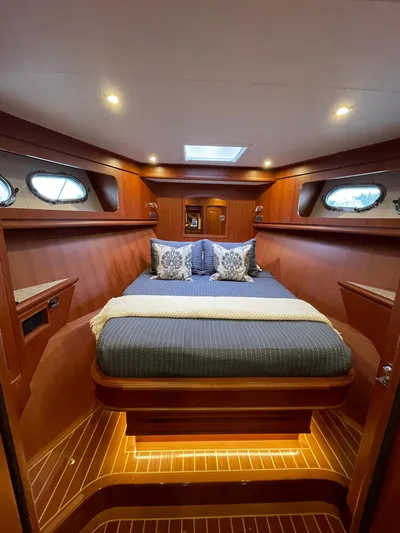 Oasis Yacht Photos Pics Luxurious cabin interior of 2024 Northwest 55 yacht with elegant wood finish and cozy bedding.