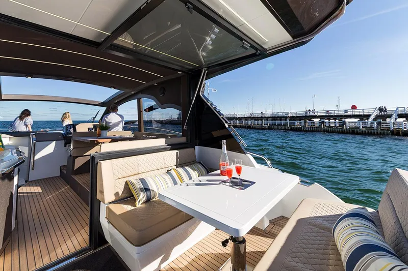  Yacht Photos Pics Manufacturer Provided Image: Galeon 425 HTS 2021 yacht with outdoor seating and drinks, docked by a pier.