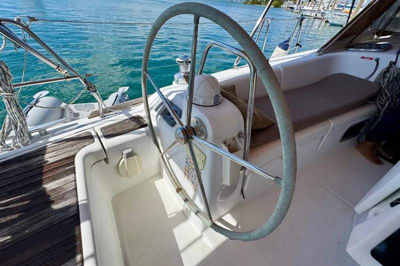  Yacht Photos Pics Steering wheel of 2008 Beneteau Oceanis 40 sailboat, docked by clear blue water.
