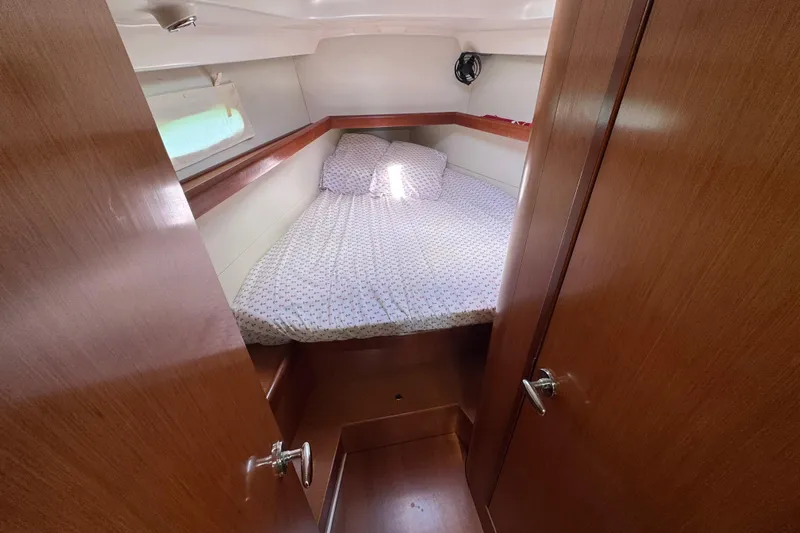  Yacht Photos Pics Cozy cabin interior of 2008 Beneteau Oceanis 40 sailboat with wooden finish and bed.