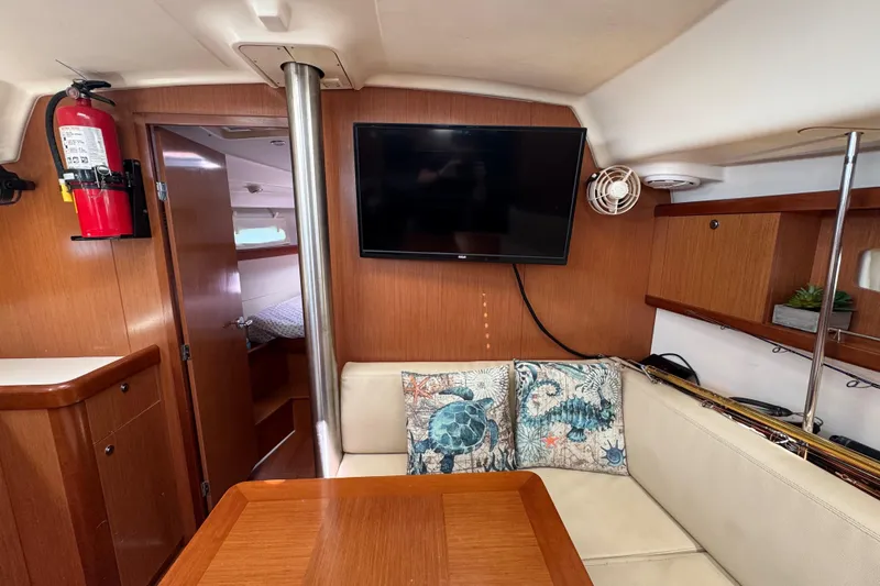  Yacht Photos Pics Interior of 2008 Beneteau Oceanis 40 yacht with cozy seating, TV, and nautical decor.