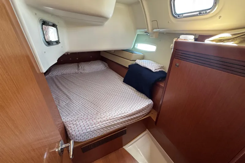  Yacht Photos Pics Cozy cabin interior of 2008 Beneteau Oceanis 40 sailboat with bed and porthole.