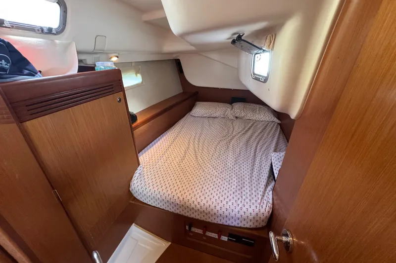  Yacht Photos Pics Cozy cabin interior of 2008 Beneteau Oceanis 40 sailboat with bed and wooden furnishings.