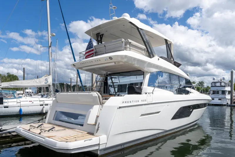  Yacht Photos Pics Luxury 2022 Prestige 520 yacht docked at marina under blue sky.