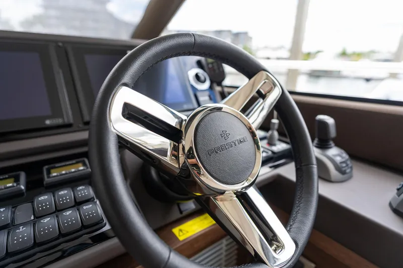  Yacht Photos Pics Steering wheel of a 2022 Prestige 520 yacht, featuring modern controls and displays.