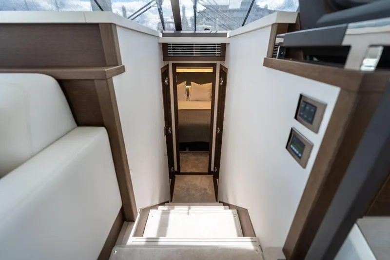  Yacht Photos Pics Interior view of 2022 Prestige 520 yacht, featuring stairs leading to a cozy bedroom.