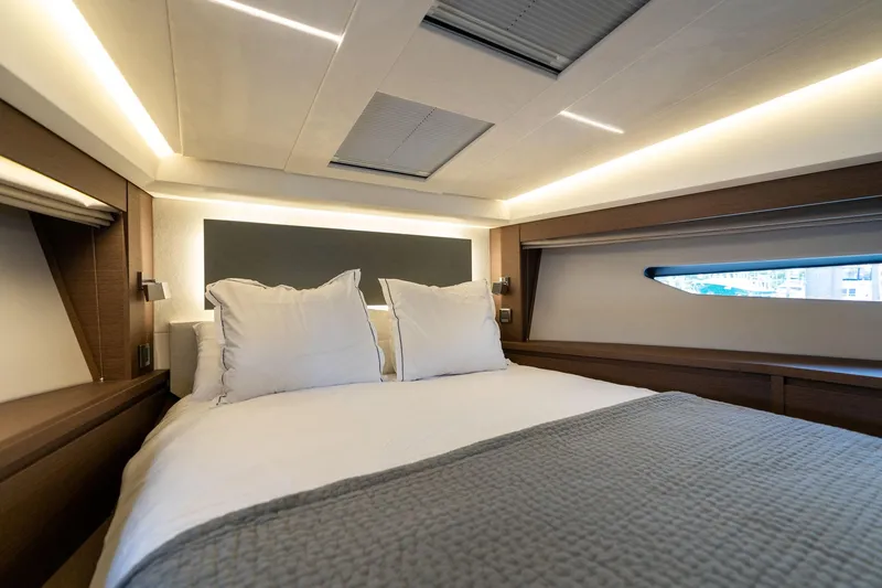  Yacht Photos Pics Luxurious bedroom interior of 2022 Prestige 520 yacht with modern lighting and cozy bedding.