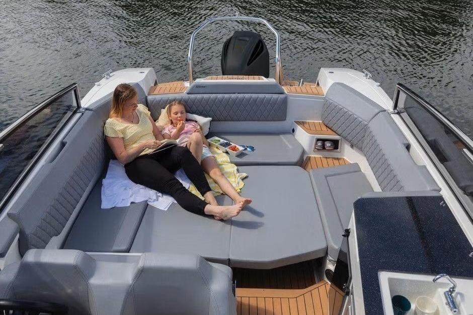 Mother and child relaxing on a 2023 Silver Raptor DCz boat, enjoying a peaceful day.