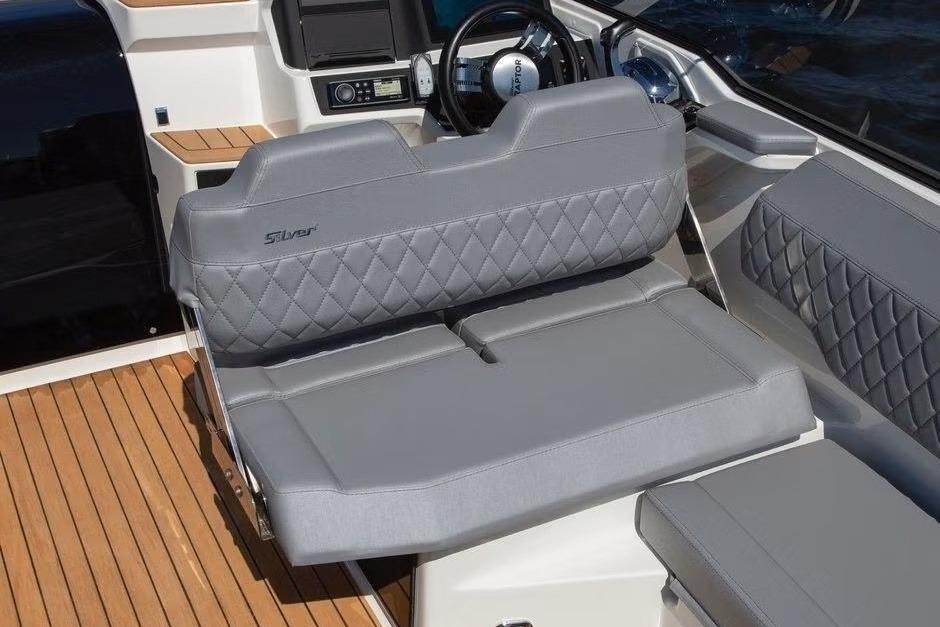 2023 Silver Raptor DCz boat interior with gray quilted seating and wooden flooring.