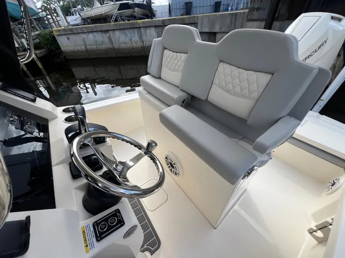  Yacht Photos Pics 2025 Scout 261 XSS boat interior with steering wheel and cushioned seating.