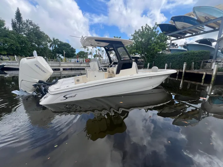  Yacht Photos Pics 2025 Scout 261 XSS boat docked on calm water under a partly cloudy sky.