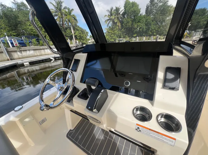  Yacht Photos Pics 2025 Scout 261 XSS boat dashboard with steering wheel, touchscreen, and cup holders.