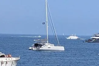 Dauntless Yacht Photos Pics Sailing catamaran NEEL 51, 2022 model, on calm blue sea with other boats nearby.