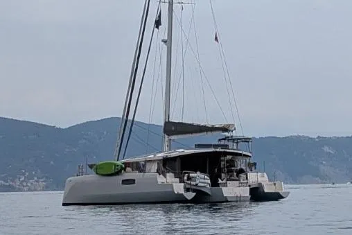 Dauntless Yacht Photos Pics Trimaran NEEL 51 sailing on calm waters, mountains in the background, 2022 model.
