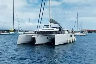 Dauntless Yacht Photos Pics 2022 NEEL 51 trimaran yacht docked in a marina, under a partly cloudy sky.