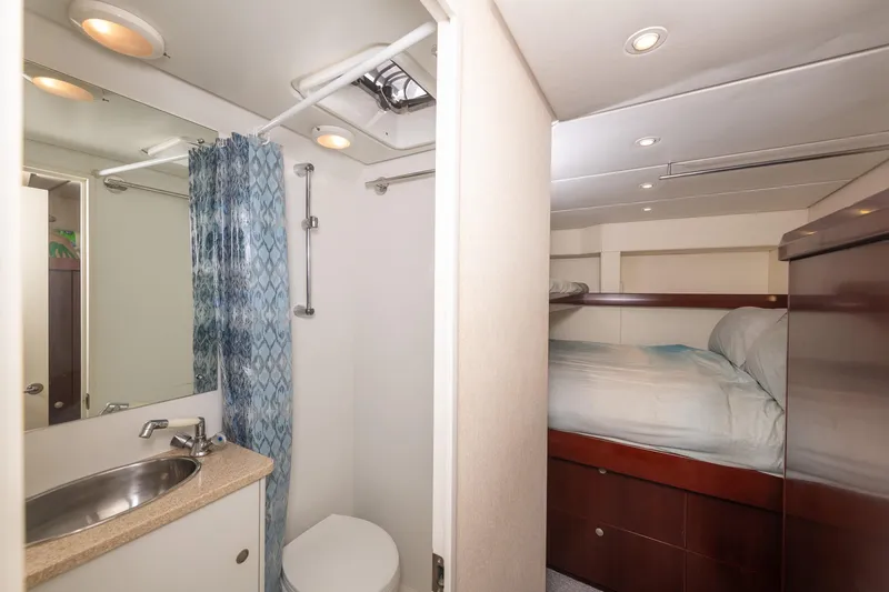 Toccata Yacht Photos Pics Interior of 2011 Circa Marine FPB64 yacht showing bathroom and cozy bedroom.