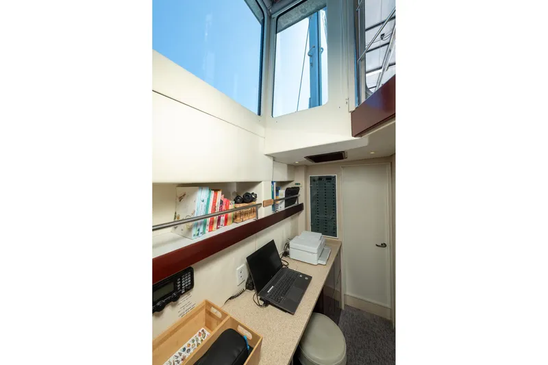Toccata Yacht Photos Pics Office space inside 2011 Circa Marine FPB64 yacht with desk, laptop, and books.