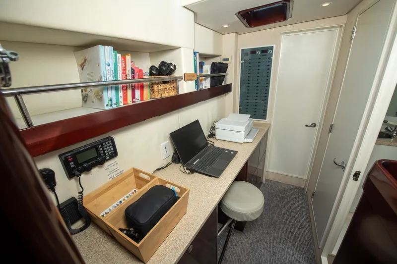 Toccata Yacht Photos Pics Office area inside 2011 Circa Marine FPB64 yacht with laptop, books, and communication equipment.