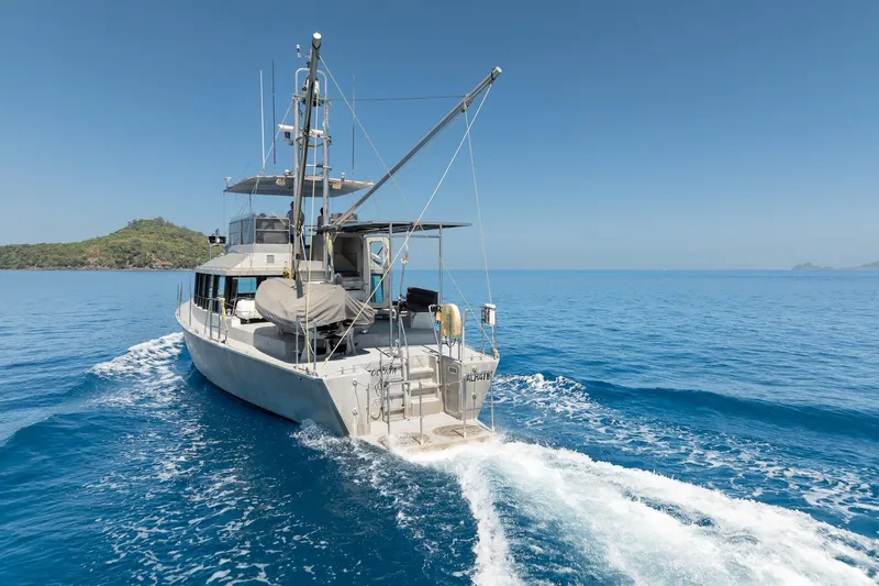Toccata Yacht Photos Pics 2011 Circa Marine FPB64 yacht cruising in clear blue ocean near lush island.