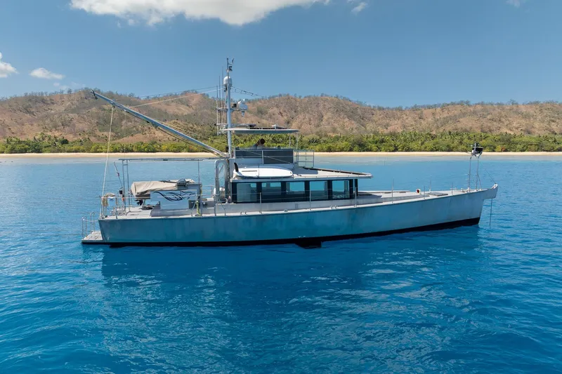 Toccata Yacht Photos Pics 2011 Circa Marine FPB64 yacht anchored in clear blue water near a scenic coastline.