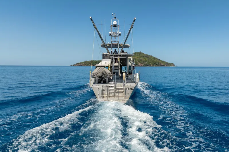 Toccata Yacht Photos Pics Circa Marine FPB64 yacht cruising near an island, 2011 model, clear blue ocean.