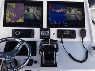  Yacht Photos Pics Control panel of a 2016 Intrepid 400 Center Console with navigation screens and steering wheel.