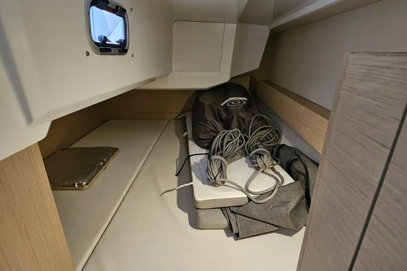  Yacht Photos Pics Interior storage space of 2022 Beneteau Oceanis 30.1 sailboat with ropes and equipment.
