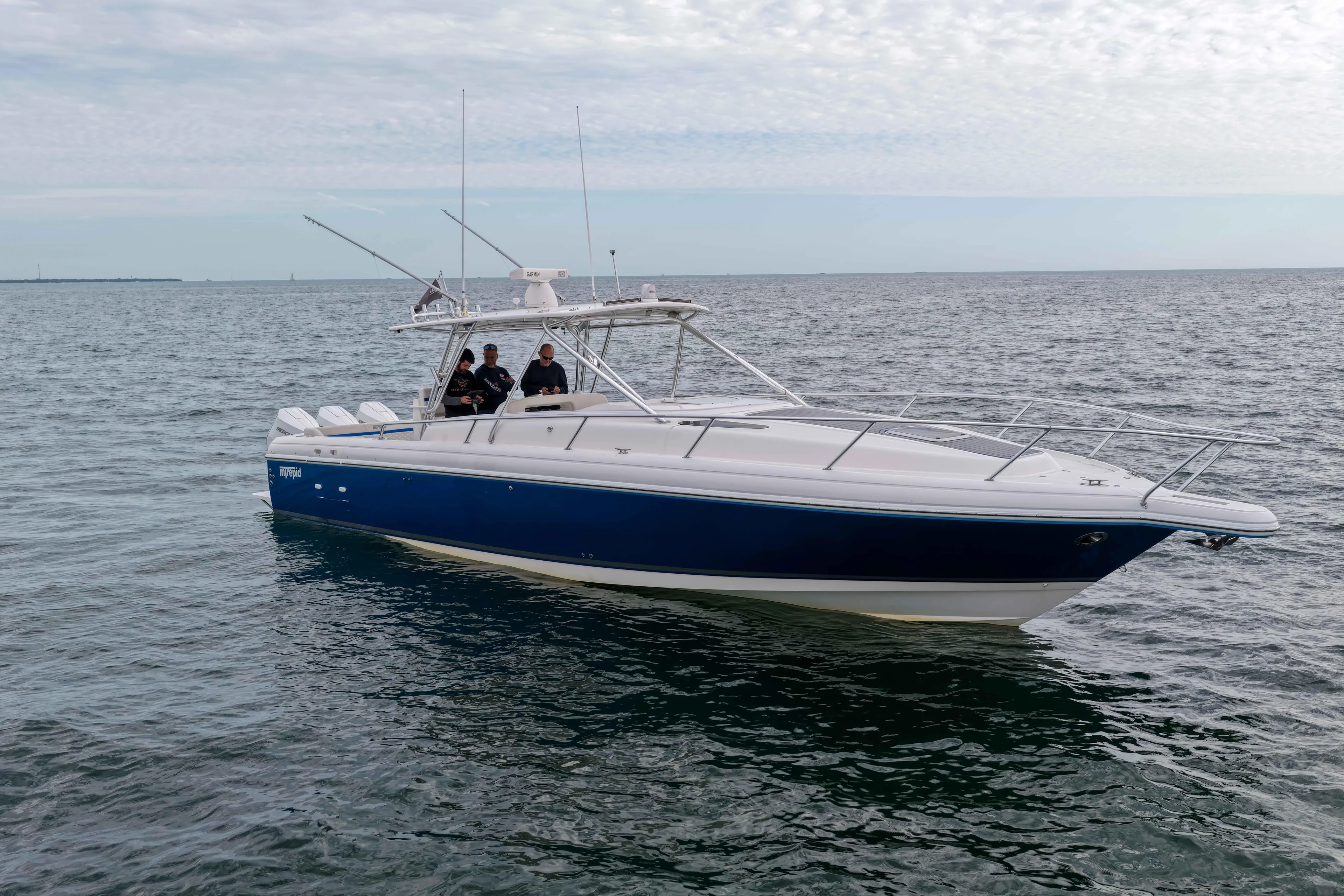  Yacht Photos Pics 2003 Intrepid 377 Walkaround boat on open water, featuring sleek design and blue hull.