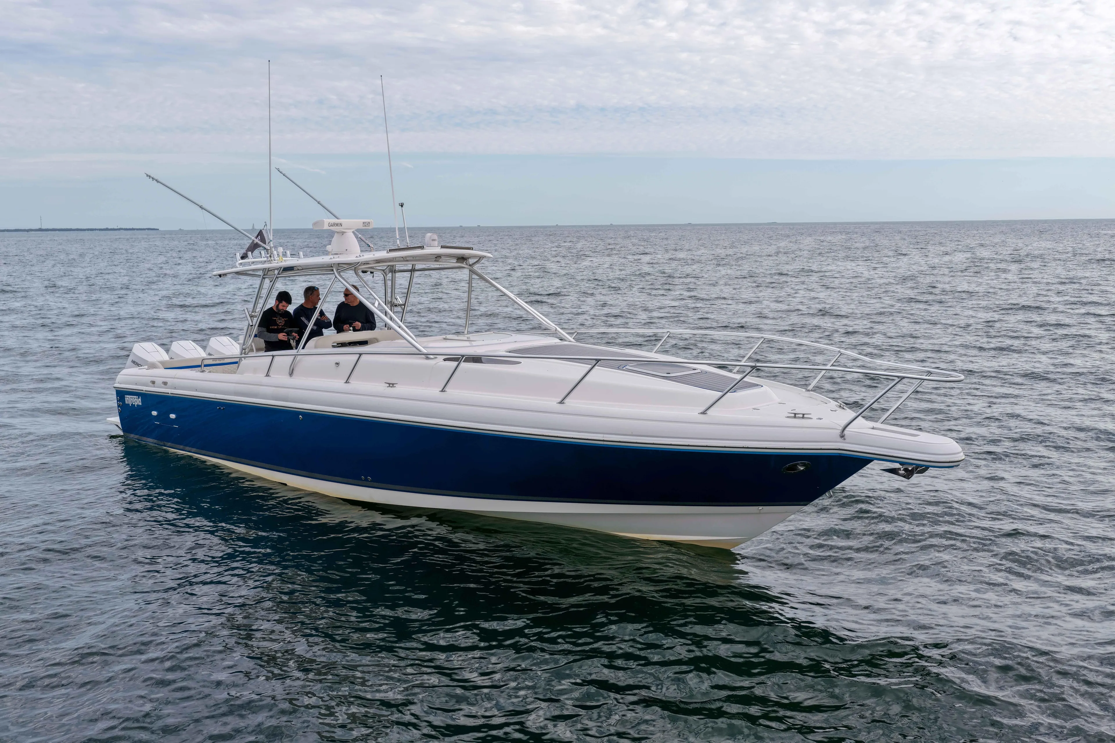  Yacht Photos Pics 2003 Intrepid 377 Walkaround boat on open water, featuring sleek design and blue hull.