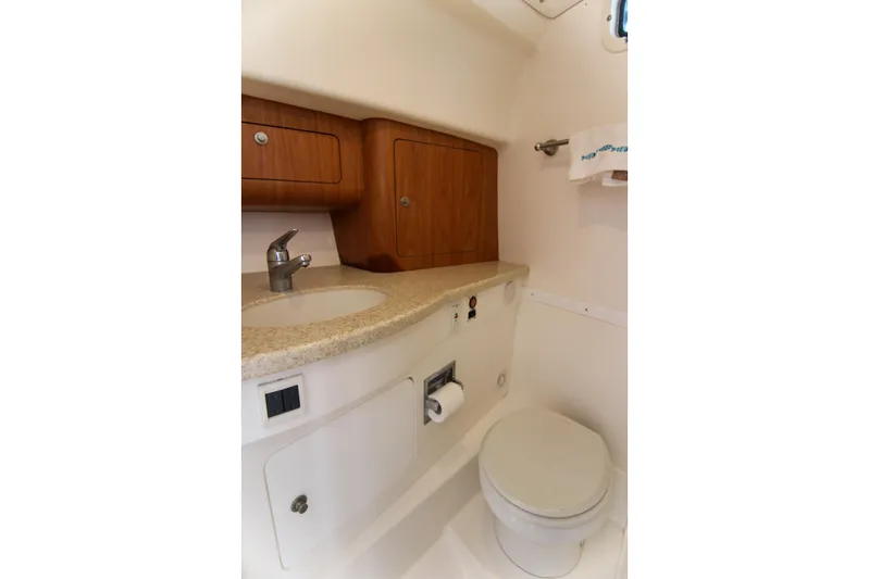  Yacht Photos Pics 2003 Intrepid 377 Walkaround boat bathroom with sink, toilet, and wooden cabinets.