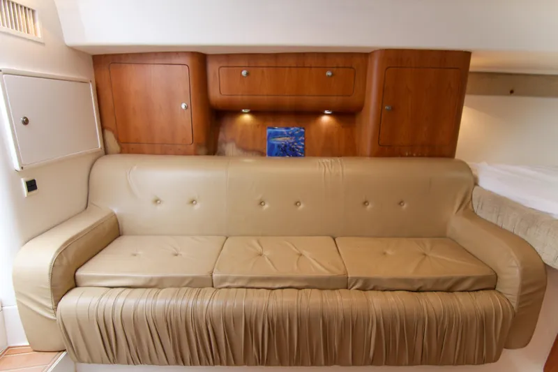  Yacht Photos Pics 2003 Intrepid 377 Walkaround interior with beige leather sofa and wooden cabinets.