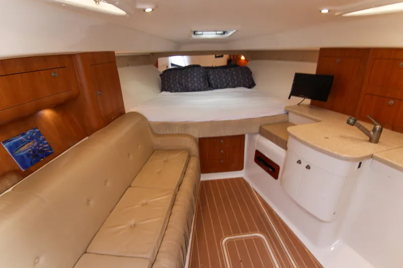  Yacht Photos Pics 2003 Intrepid 377 Walkaround cabin with bed, sofa, and kitchenette.