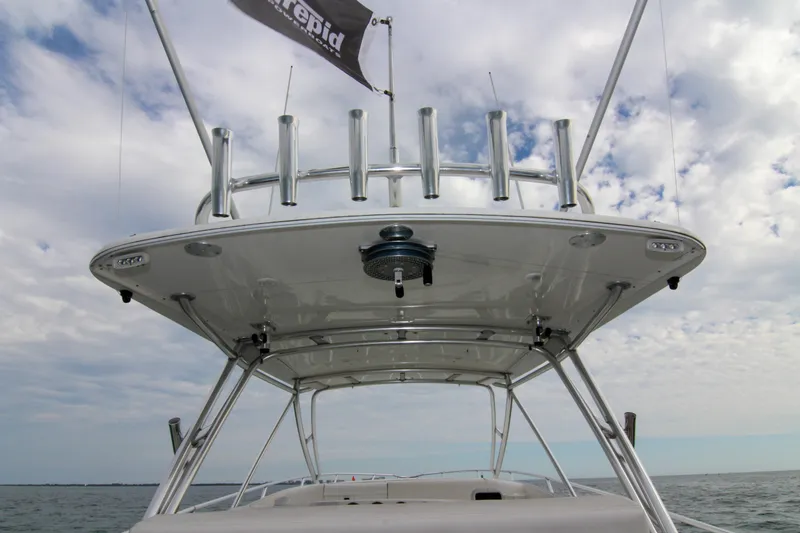  Yacht Photos Pics 2003 Intrepid 377 Walkaround boat with rod holders and canopy, under a cloudy sky.