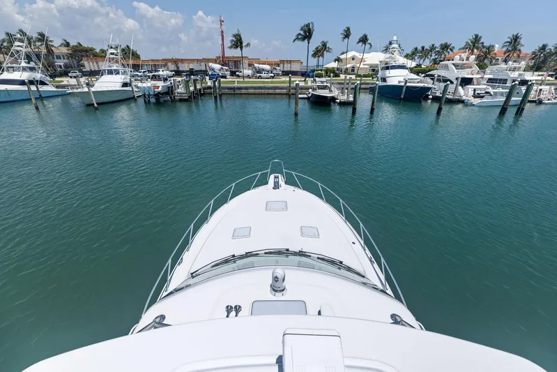 Milling Time Yacht Photos Pics Bow view of 2016 Hatteras Express Sportfish in a marina with palm trees.