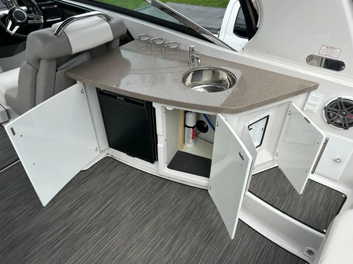  Yacht Photos Pics 2018 Four Winns Horizon H290 boat interior with kitchenette, sink, and storage cabinets open.