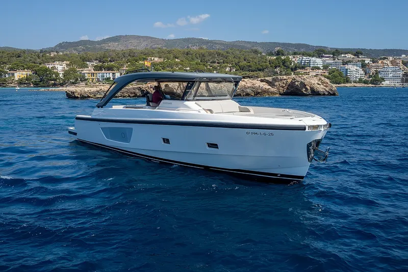  Yacht Photos Pics 2024 Bluegame 54 yacht cruising on clear blue waters near a scenic coastline.