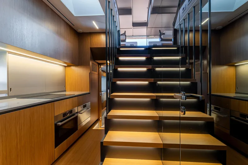  Yacht Photos Pics Modern interior of 2024 Bluegame 54 yacht with sleek wooden staircase and kitchen.
